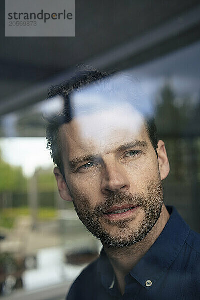 Mature businessman looking through window