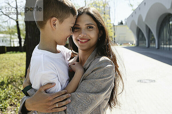 Happy mother embracing son at park