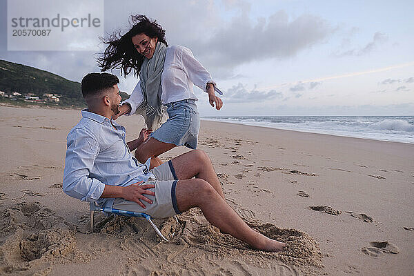 Happy couple enjoying together on sand at beach