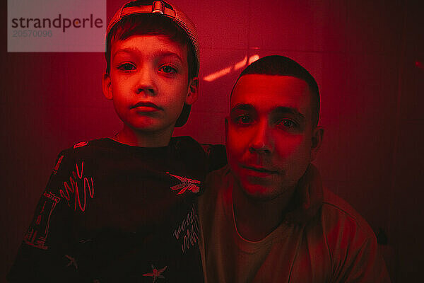 Boy with arm around father amidst red light