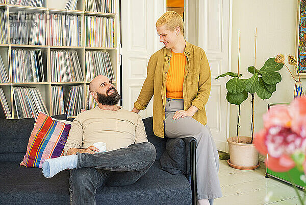 Man and woman sitting on sofa at home