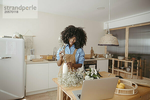 Florist arranging flowers in vase at home