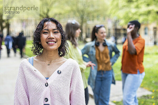 Smiling woman standing with friends in background