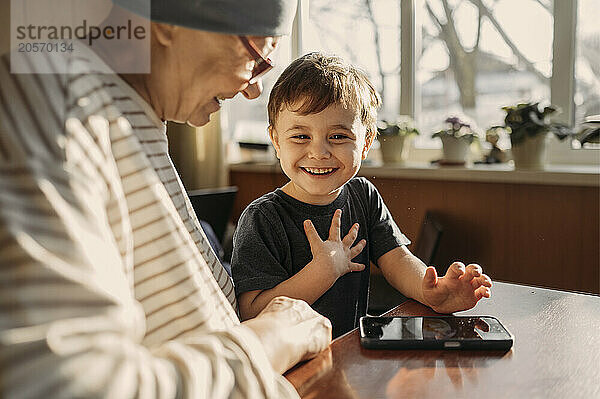 Cheerful boy enjoying with grandmother at home