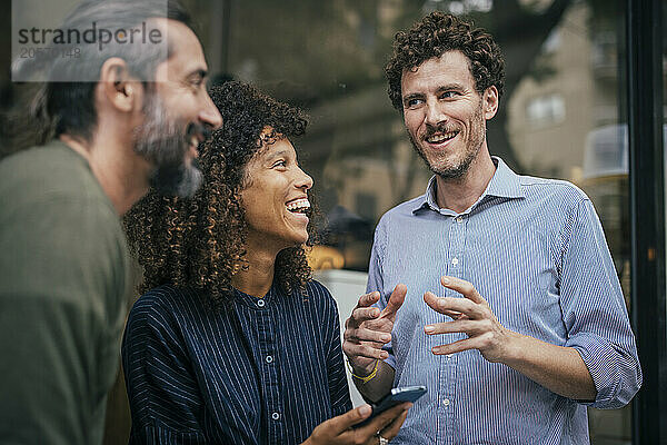 Smiling coworkers sharing ideas with each other