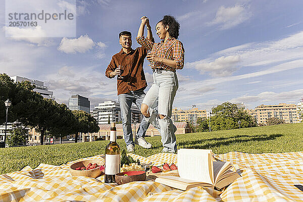 Happy man dancing with girlfriend at public park