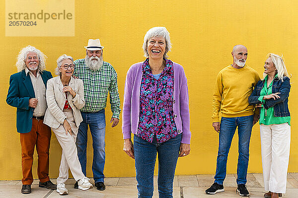 Happy mature woman with senior friends in background