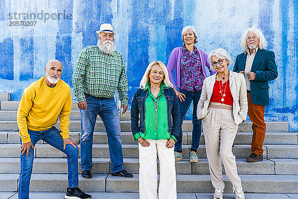 Happy friends standing together on steps