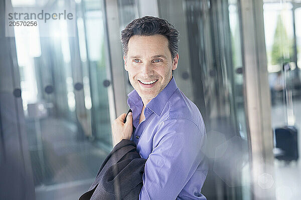 Smiling handsome mature businessman at airport terminal