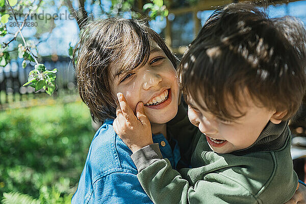 Playful brothers embracing in back yard