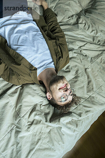 Young handsome man lying on bed at home