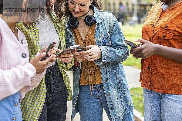 Female friends sharing smart phones