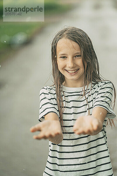 Smiling girl wearing striped t-shirt and enjoying in rain