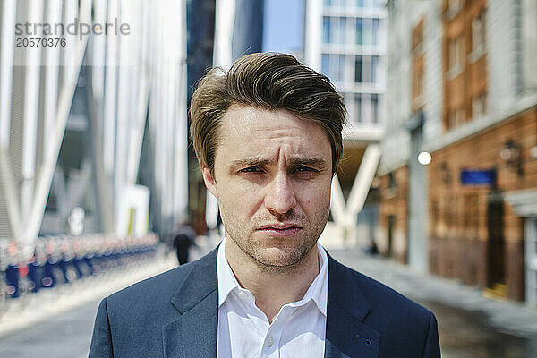 Businessman standing on street near buildings