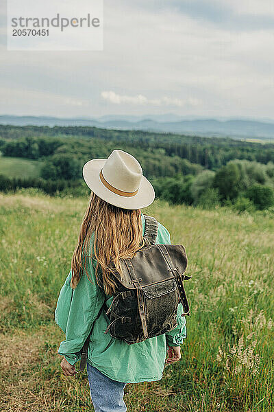 Young woman with backpack hiking on mountain