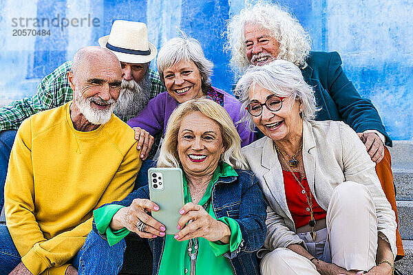 Happy woman taking selfie with friends sitting together