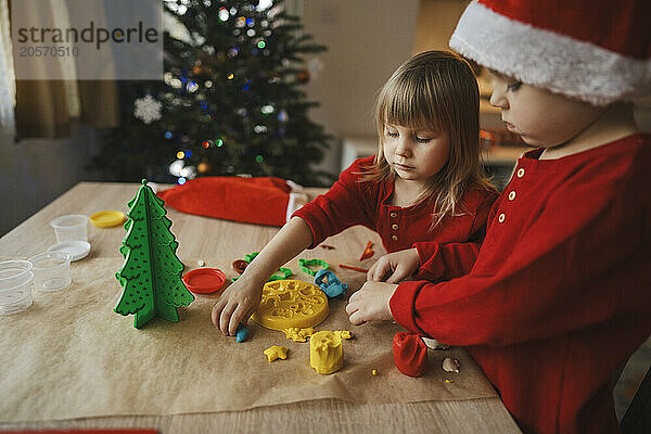 Brother and sister making Christmas decorations at home