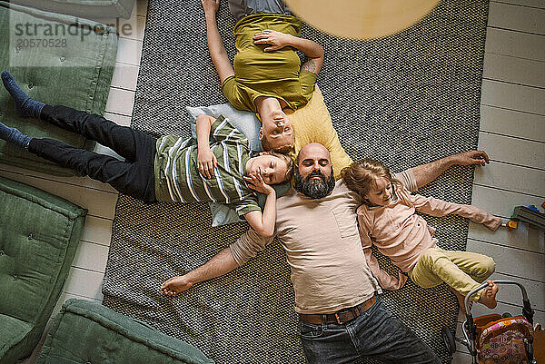 Family sleeping together on carpet at home