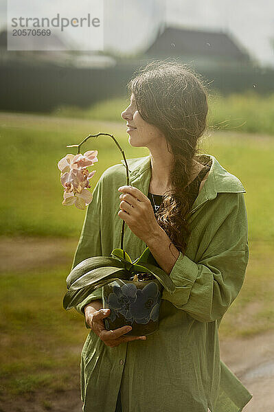 Mature woman holding orchid plant