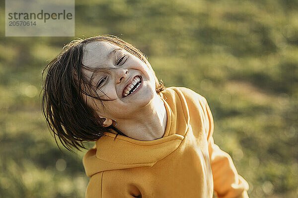 Cheerful boy wearing yellow hoodie