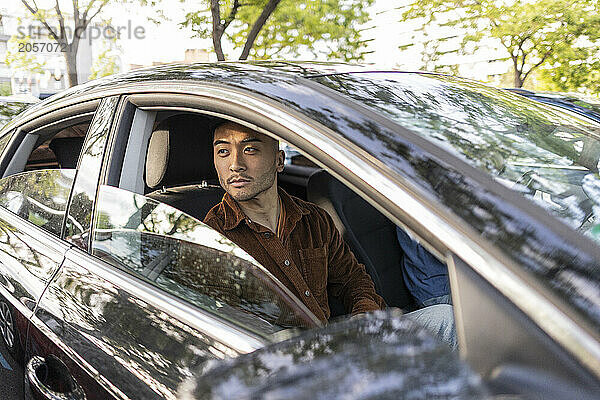 Thoughtful young man sitting in car