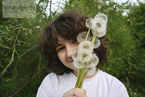 Smiling girl with bunch of dandelions