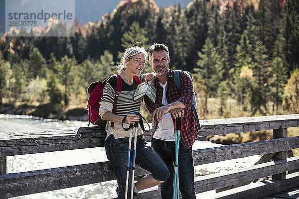 Couple with hiking poles in front of wooden railing