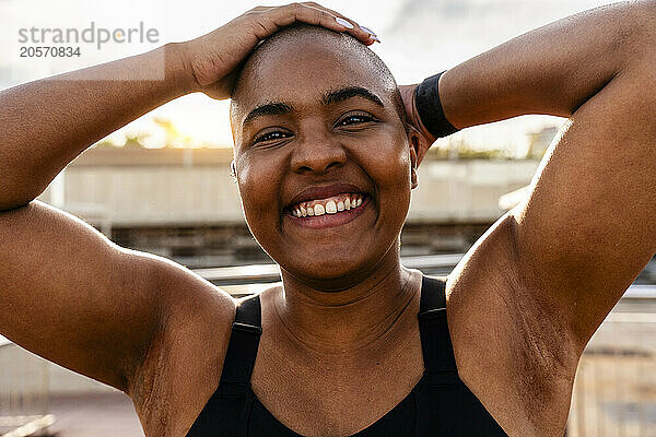 Happy bald woman with hands on head