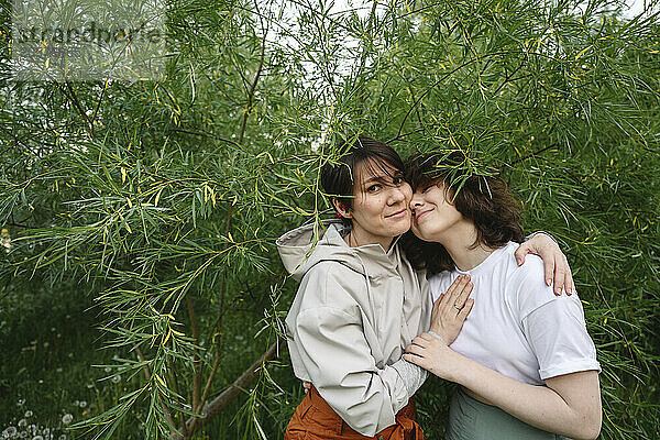 Mother and daughter amidst green plants in park