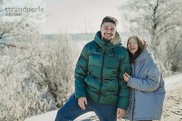 Smiling couple enjoying in winter forest