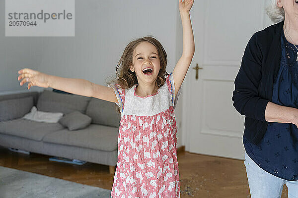 Cheerful girl dancing in living room