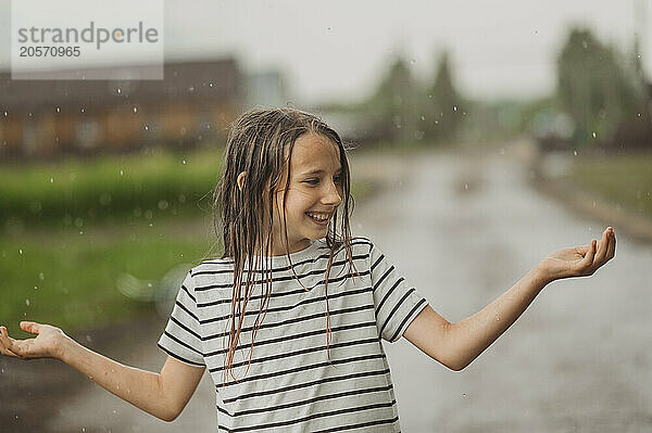 Happy girl with wet hair having fun in rain