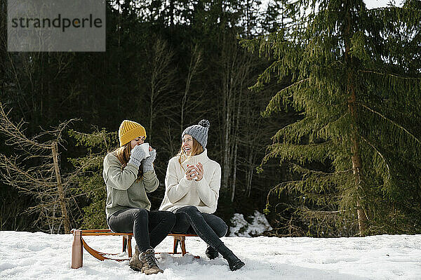 Happy friends enjoying coffee in winter vacation