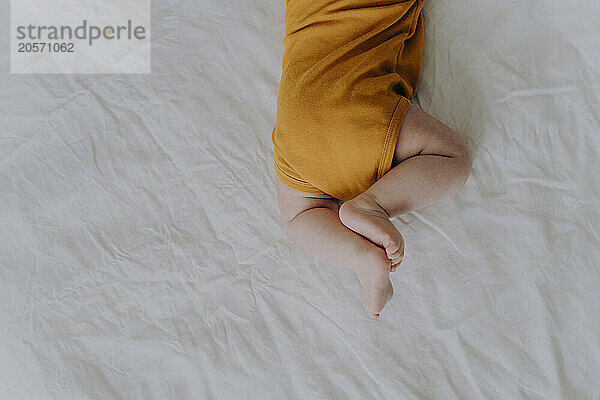 Baby boy crawling on bed at home