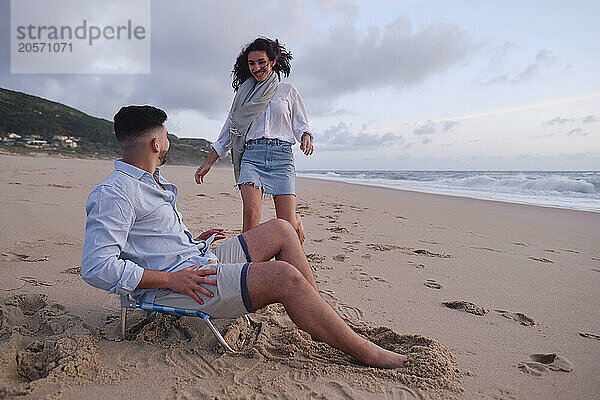 Woman enjoying with man relaxing at beach