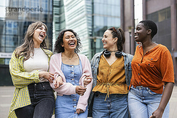 Cheerful female friends walking in city