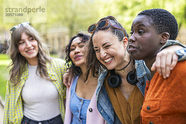 Happy multiracial friends with arms around