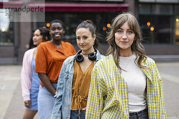 Young woman standing in front of friends