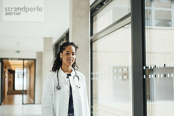 Confident young female doctor in hospital corridor