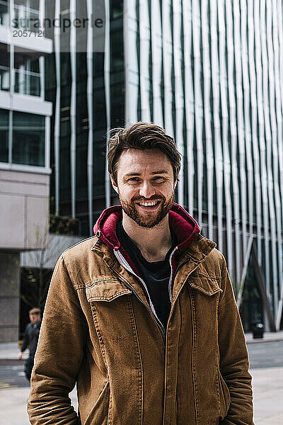 Handsome man smiling and standing near buildings