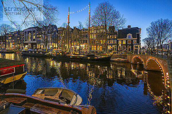 Illuminated boats and canals at blue hour in Amsterdam