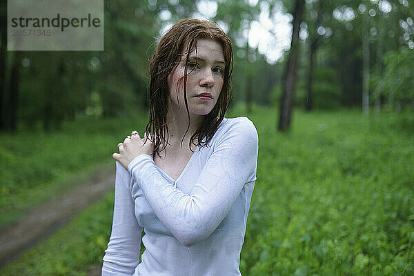 Woman with hand on shoulder in forest