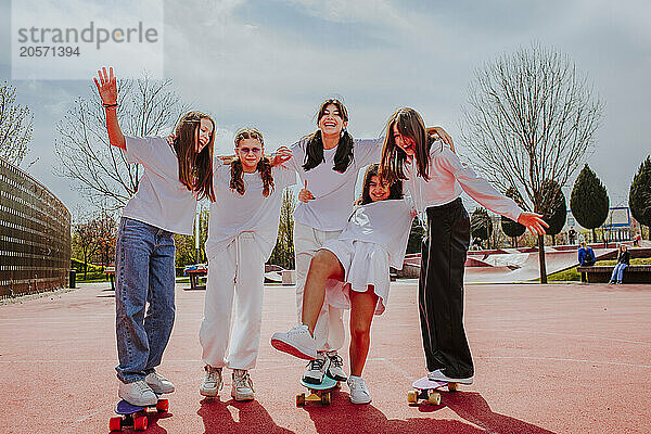 Playful girl with friends skateboarding at playground