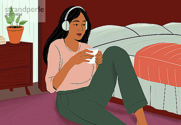 Woman wearing wireless headphones and holding coffee cup sitting near bed at home