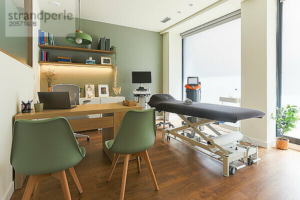 Examination room with medical equipment and desk in clinic