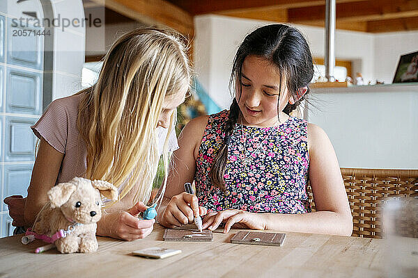 Multiracial girls playing at dining table in home