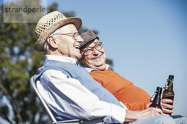 Happy friends enjoying beer at field