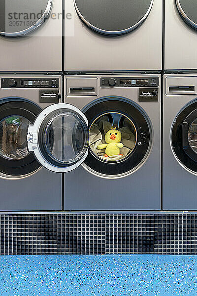 Yellow duck in open washing machine at laundromat