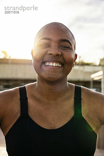 Smiling bald woman on sunny day under sky