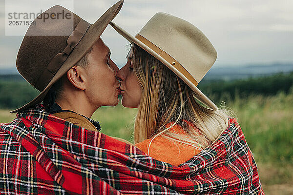 Romantic young couple kissing at meadow in mountain of Poland